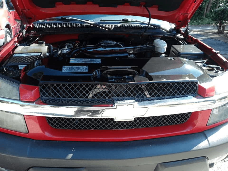 Meticulously cleaned engine bay on a red Chevrolet pickup after professional detailing