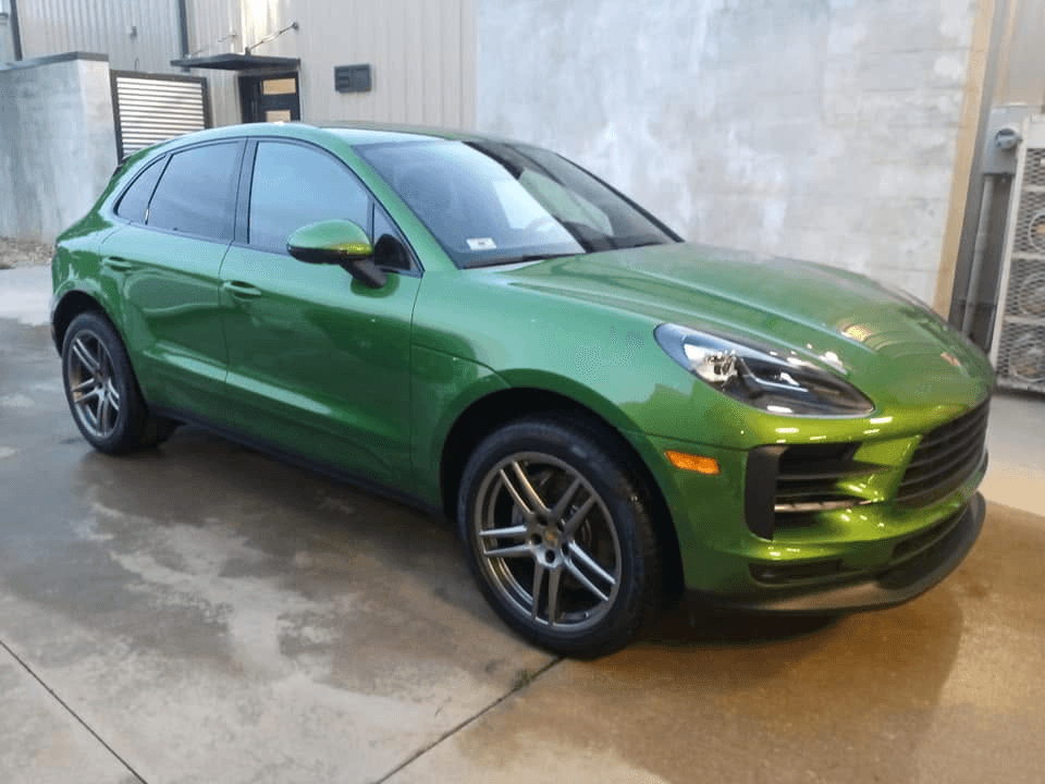 Metallic green Porsche SUV with a glossy finish after a professional car wash